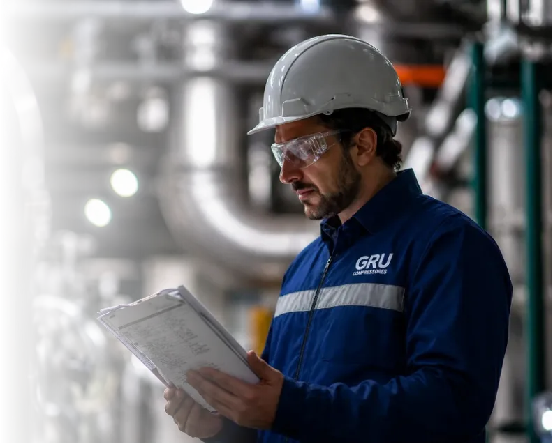 Técnico da GRU Compressores realizando serviços em compressor industrial